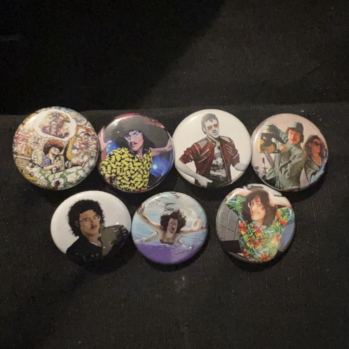 Photograph of 7 Weird Al Yankovic themed buttons, showing the covers of Weird Al Yankovic, In 3-D, Eat It, Lke A Surgeon, Even Worse, Off The Deep End, and a photograph of Al.